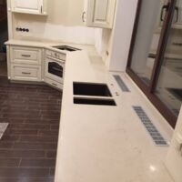 Столешница , переходящая в подоконник, из кварцита Caesarstone 5220, который имитирует натуральный мрамор.