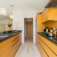 Цвет PRIMROSE YELLOW в интерьере стильной кухни. Столешницы из темного серого кварцита.