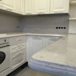 Кухонная столешница с фигурным фасоном из кварцита Caesarstone 5212. Рабочая поверхность (фартук) из того же материала.