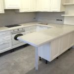 Столешницы из кварцевого камня Caesarstone 5212. Кухонный стеновой фартук и нога для барной стойки также выполнены из этого камня.